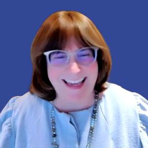 Photo of a woman with brown hair and bangs, surrounded by a blue border