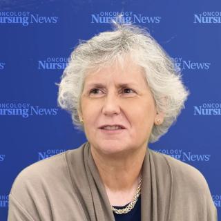 Image of a woman with white hair in front of an Oncology Nursing News blue background