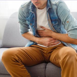 Photo of a person holding their abdomen in discomfort
