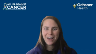 Smiling woman in front of a blue video call background with logos that say "All in Against Cancer" and "Ochsner Health" above her