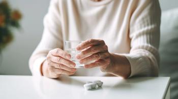 older woman sitting at a table with a glass of water