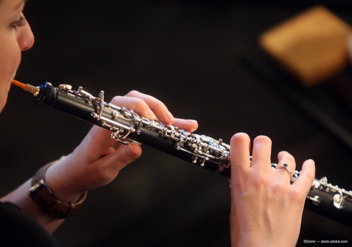 Image of a person in profile playing an oboe