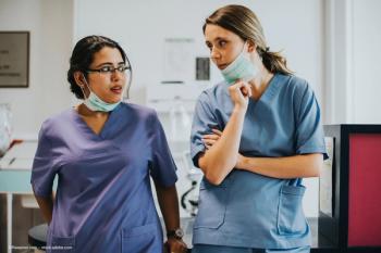 An image of two medical professionals in medical scrubs standing and talking in a medical facility. Concept image for surgery, consultant and resident ophthalmologists, immediate sequential bilateral cataract surgery, outcomes for ISBCS and eye care. Image credit: ©Rawpixel.com – stock.adobe.com