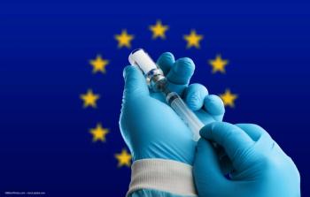 Gloved hands fill a syringe in front of the European Union flag. Image credit: ©BillionPhotos.com – stock.adobe.com