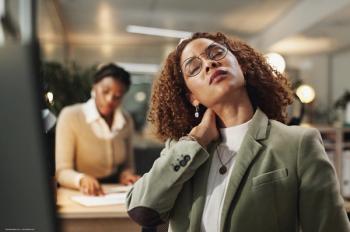 A woman with neck pain and glasses at a computer. Concept image for dry eye and fibromyalgia. Image credit: ©peopleimages.com – stock.adobe.com
