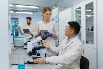 A group of scientists in a lab discuss data. Image credit: ©Liubomir – stock.adobe.com