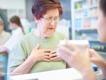 A woman wearing glasses buys medicine from a pharmacy. Image credit: ©gpointstudio – stock.adobe.com