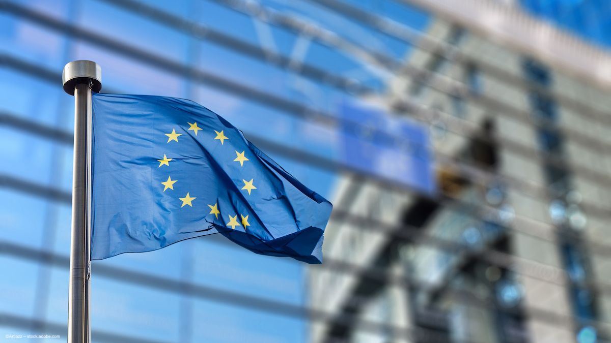 The European flag waves in front of a building. Image credit: ©Artjazz – stock.adobe.com