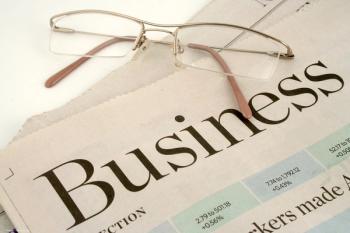 A newspaper sits folded so the heading "BUSINESS SECTION" is visible. Glasses rest on top of the paper. Image credit: ©GVictoria – stock.adobe.com