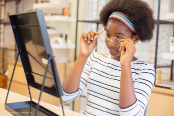 A young person tries on glasses in front of a mirror. Image credit: ©eakgrungenerd – stock.adobe.com