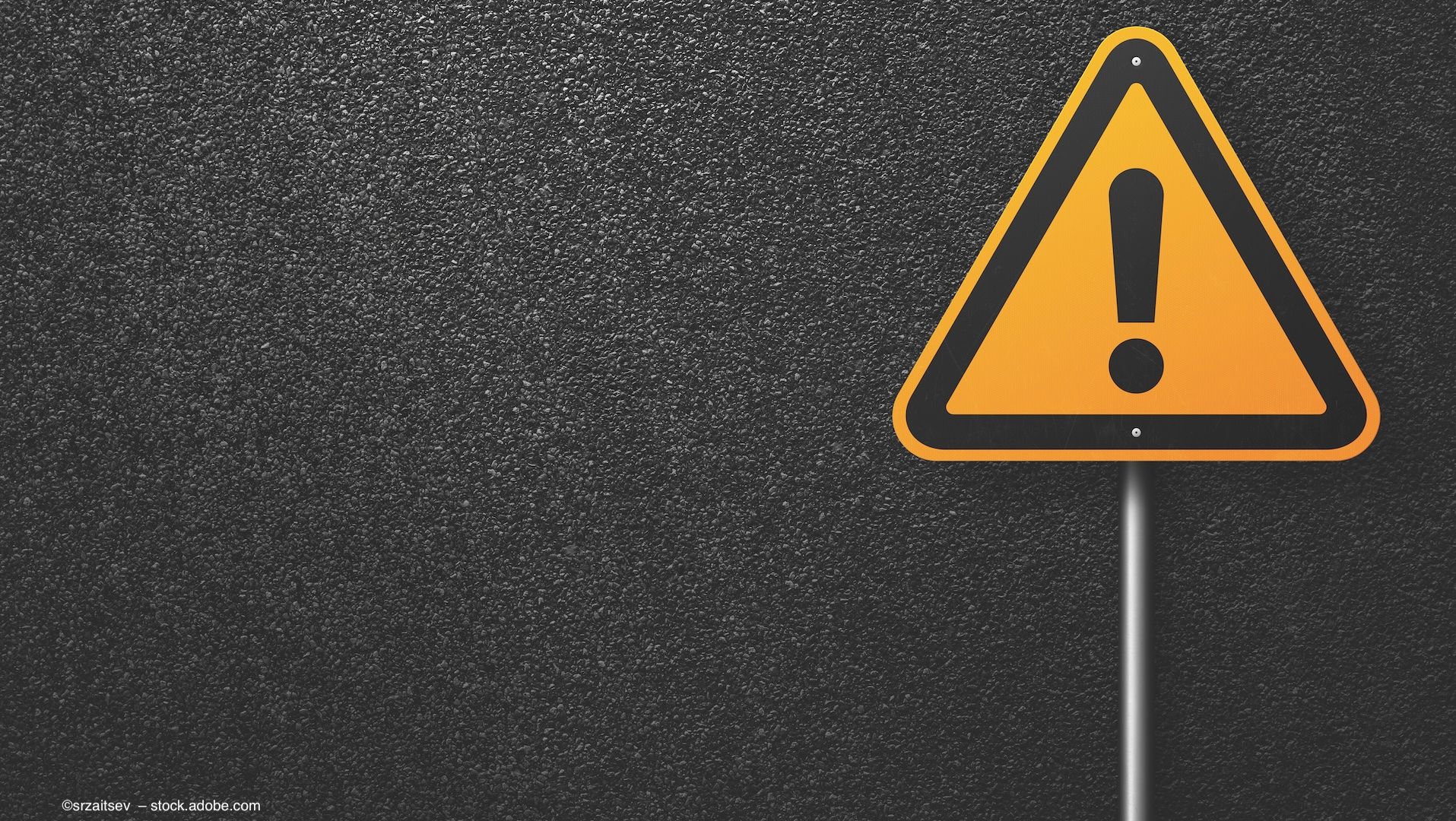 A bright-yellow hazard sign against a stark black background. Image credit: ©srzaitsev  – stock.adobe.com