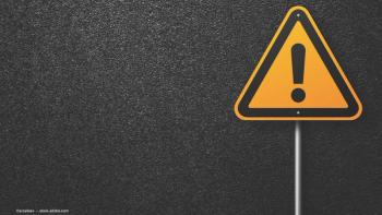 A bright-yellow hazard sign against a stark black background. Image credit: ©srzaitsev – stock.adobe.com