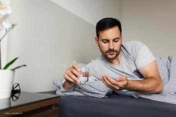 A man in a bed takes a pill. Concept image for oral therapy, danegaptide non proliferative diabetic retinopathy medication. Image credit: ©Jelena – stock.adobe.com