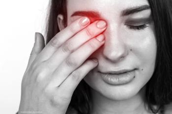 A black-and-white image of a woman placing her hand over her eye, as if in pain. A red glow on her eye area indicates she is experiencing neuropathic corneal pain. Image credit: ©mykolasamoilenk – stock.adobe.com