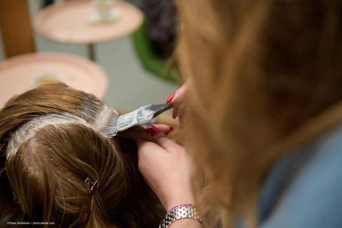 A stylist applies dye to a client's hair with a brush. Image credit: ©Taras Grebinets – stock.adobe.com