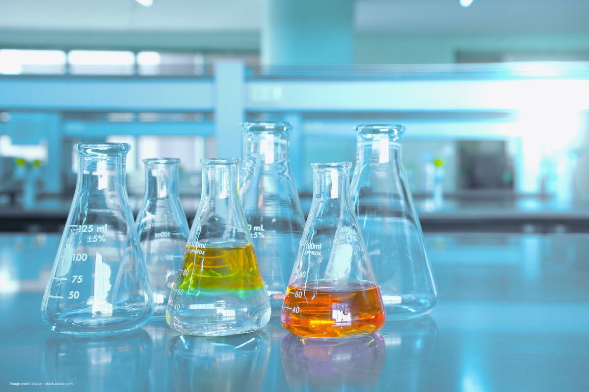 A row of beakers with yellow and orange fluid in a laboratory. Concept image for microbial lutein production, bioengineering, sustainable synthesis for cataract cornea age-related macular degeneration (AMD) and retinal disease. Image credit: bidala – stock.adobe.com