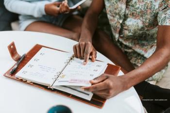 A person checks their agenda planner. Image credit: ©rawpixel.com – stock.adobe.com