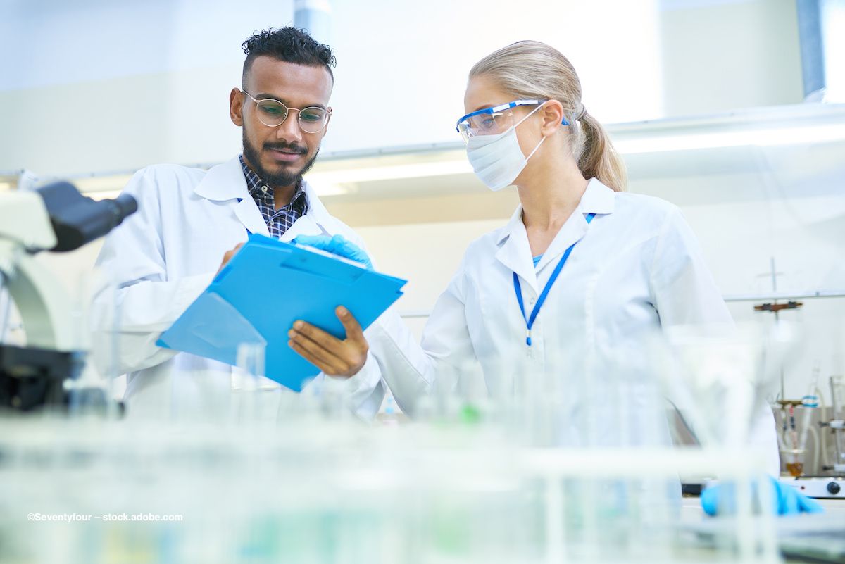 Scientists in a laboratory consult a clipboard and record data. Image credit: ©Seventyfour – stock.adobe.com