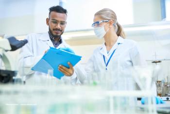 Scientists in a laboratory consult a clipboard and record data. Image credit: ©Seventyfour – stock.adobe.com