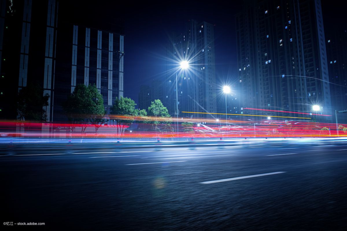 A series of streetlights with blurs/halos around them. There are blurred, red streaks of lights from cars driving by. Image credit: ©忆江 – stock.adobe.com