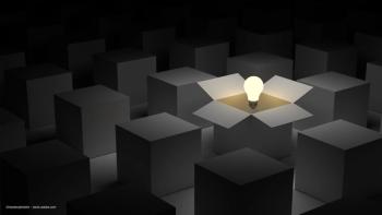 A lightbulb hovering in an open box, in a room full of closed boxes. Image concept for "thinking outside the box," and revisiting or amending perspectives  to treatment of retinal disease. Image credit: ©masterzphotofo – stock.adobe.com