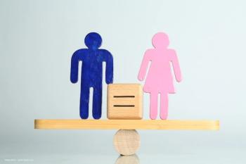 Symbols representing a man and a woman stand on either side of a wooden scale, which is currently balanced. Image credit: ©New Africa – stock.adobe.com