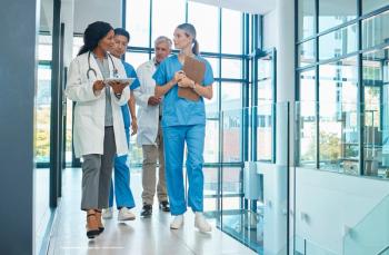 A group of doctors and scientists walk through a laboratory. Image credit: ©Oostendorp/peopleimages.com – stock.adobe.com
