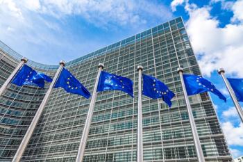 EU flags wave in the wind outside a building. Image credit: ©Sergii Figurnyi – stock.adobe.com