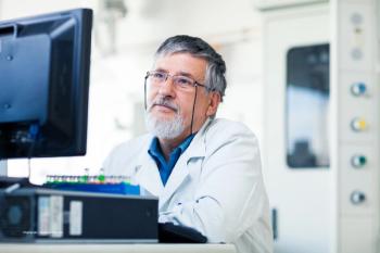 A researcher sits at a computer. Image credit: ©lightpoet – stock.adobe.com