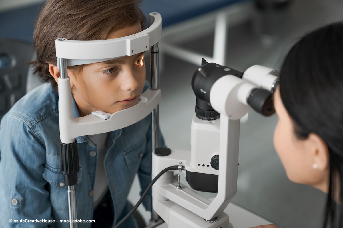 A child situates his head in a slit lamp for eye examination. Image credit: InsideCreativeHouse – stock.adobe.com