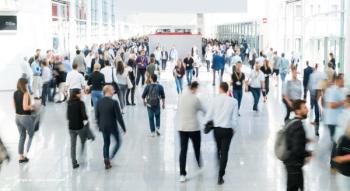 A crowd of people move about a conference floor. Image credit: ©engel.ac – stock.adobe.com