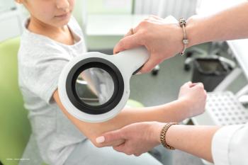 A dermatologist examines a child's arm for evidence of atopic dermatitits. Concept image for link between AD and paediatric uveitis. Image credit: ©Kate – stock.adobe.com