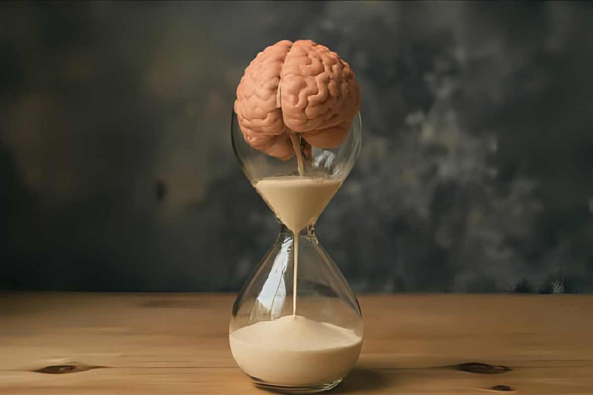 An hourglass with a brain in the top. The brain is falling through the hourglass like sand. The brain is crumbling into small pieces. The brain falls through the hourglass. Concept image for neurodegeneration, neurodegenerative disease, mitochondrial disease and biomarkers. Image created with Canva AI.