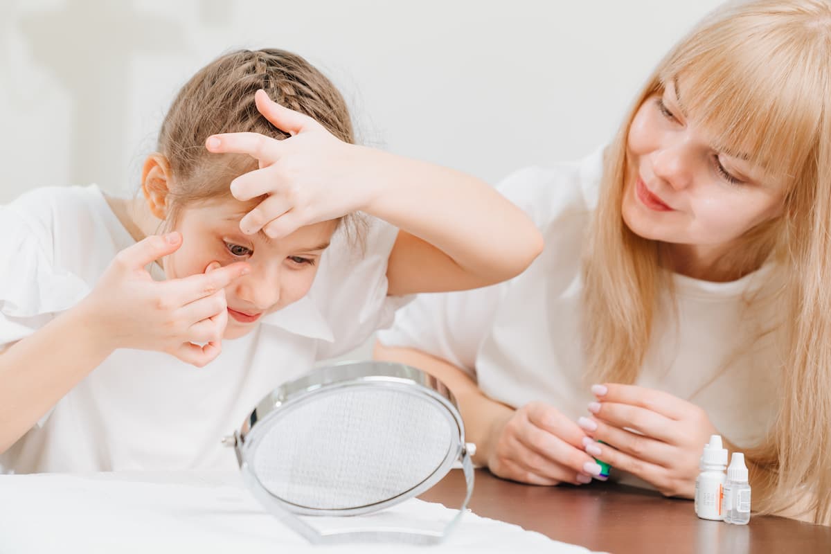 Child administering contact lens with parent Image credit: AdobeStock/andrey