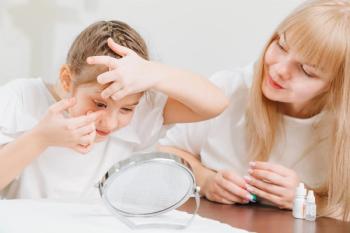 Child administering contact lens with parent Image credit: AdobeStock/andrey