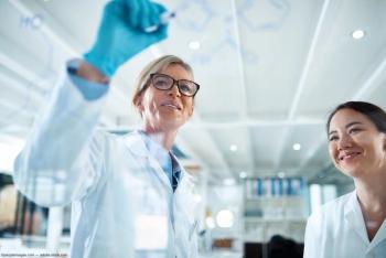 Two scientists discussing data in lab Image credit: AdobeStock/peopleimages.com