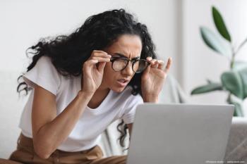 Woman holding glasses to her face straining to read a computer screen Image Credit: ©Prostock-studio - adobe.stock.com