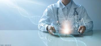 Doctor sitting with EMR device. Image credit: AdobeStock/ipopba