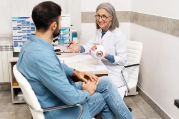 Eye doctor speaking to patient in office Image credit: AdobeStock/Maria Vitkovska