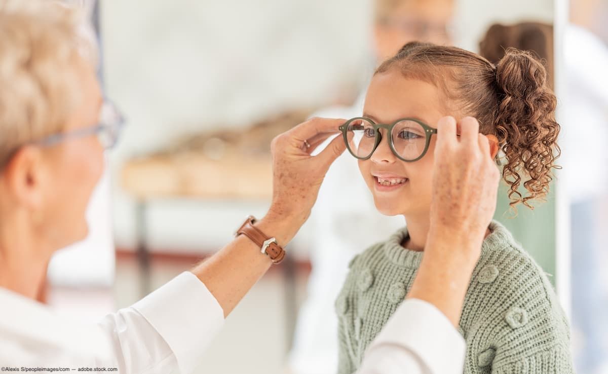 Adult helping child try on glasses Image credit: ©Alexis S/peopleimages.com - adobe.stock.com