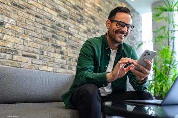 Man on couch looking at phone Image credit: AdobeStock/MoonSafari