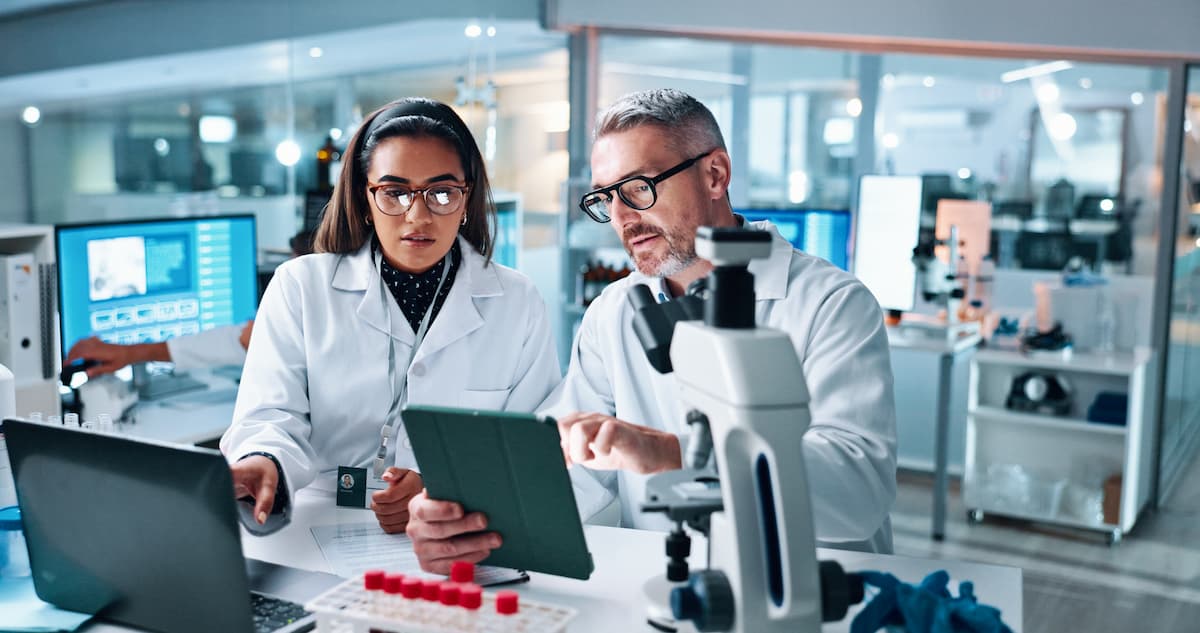 Scientists discussing results in lab Image credit: AdobeStock/CC/peopleimages.com