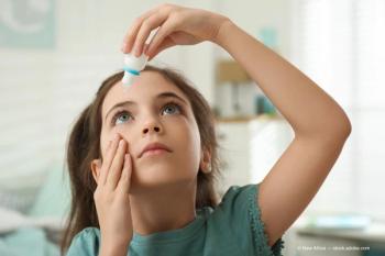 Adorable little girl using eye drops indoors (Adobe Stock / New Africa)
