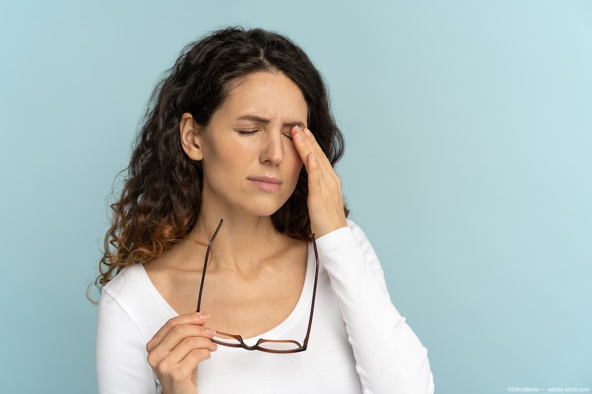 Woman with eye pain touching head Image credit: AdobeStock/DimaBerlin