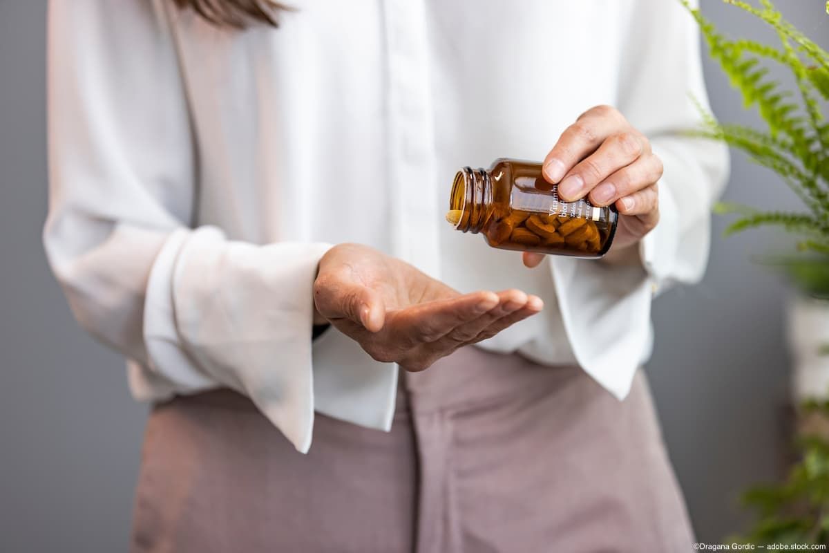 Woman pouring supplement bottle into hand Image credit: ©Dragana Gordic - adobe.stock.com