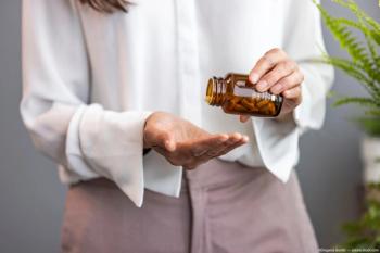 Woman pouring supplement bottle into hand Image credit: ©Dragana Gordic - adobe.stock.com