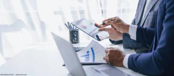 Businessmen discussing numbers at table Image credit: AdobeStock/M+Isolation_Photo