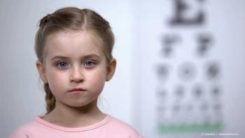 Cute little girl standing on background of visual acuity testing table, optics (Adobe Stock / motortion)