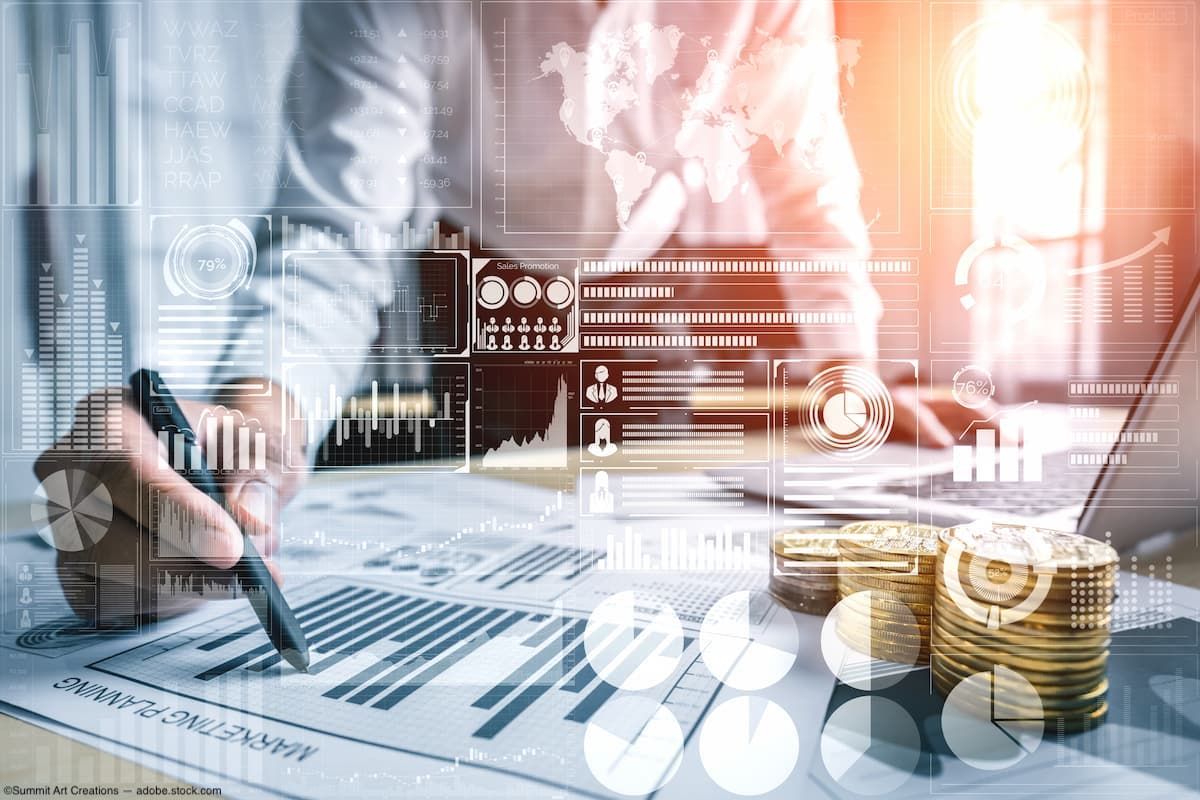 Business person planning at desk with financial graphic overlay Image credit: ©Summit Art Creations - adobe.stock.com