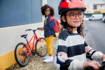 Children on bikes wearing glasses. Image credit: SightGlass Vision